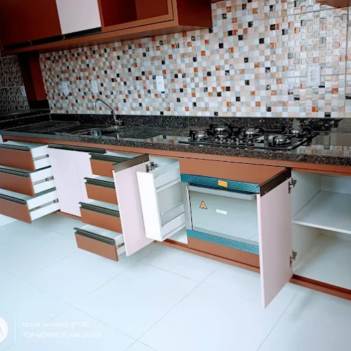 Cozinha planejada com armários claros e bancada